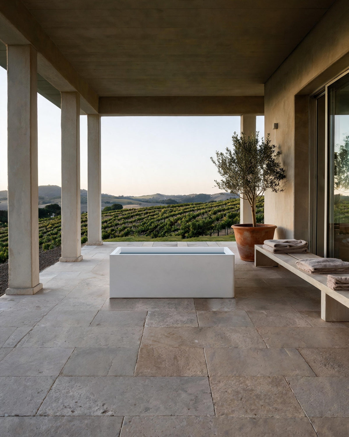 BLOCK vessel filled with cold water in a stone loggia facing vineyards at dusk