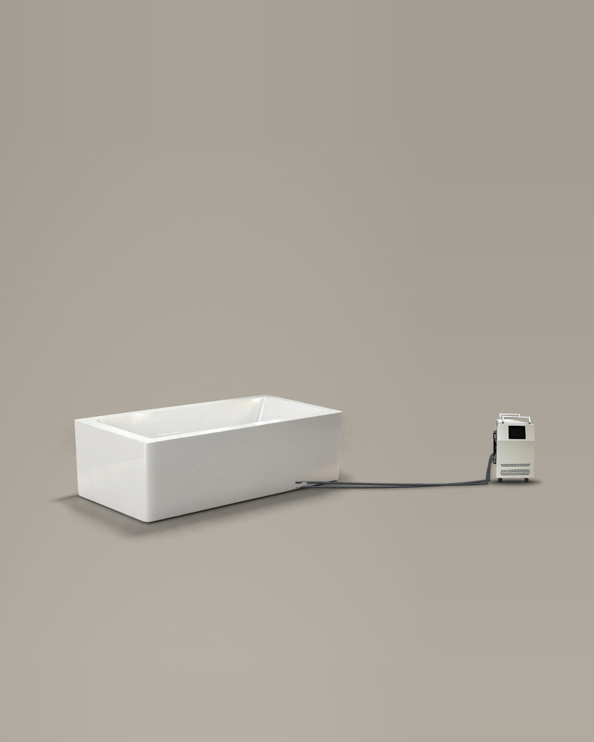 White rectangular bathing vessel on a warm grey studio backdrop beside its Hot & Cold Unit, connected by two braided hoses