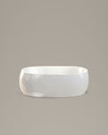COVE oval vessel in white acrylic, side view, on a warm grey studio background