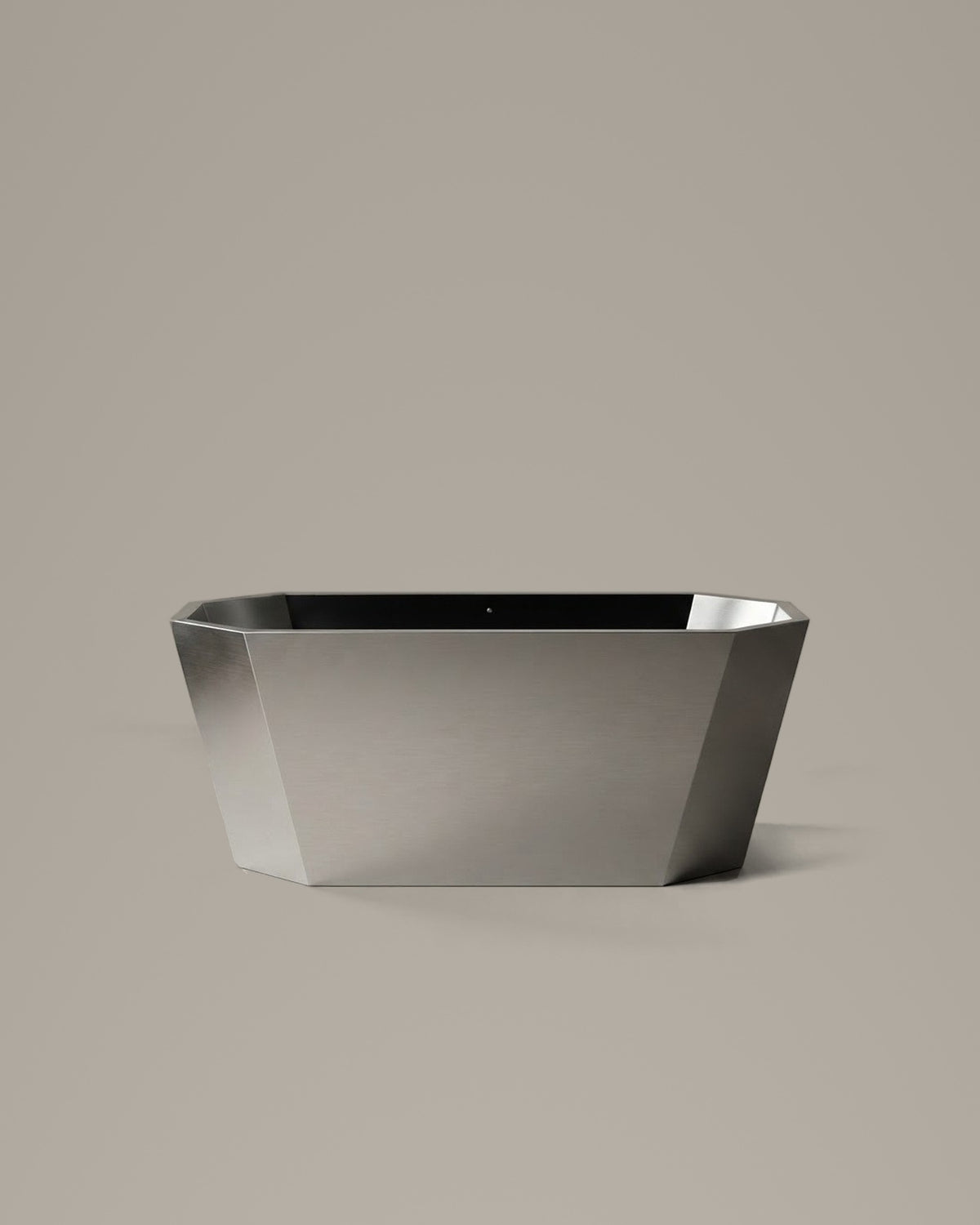 FACET octagonal vessel in Satin Steel, side view, on a warm grey studio background