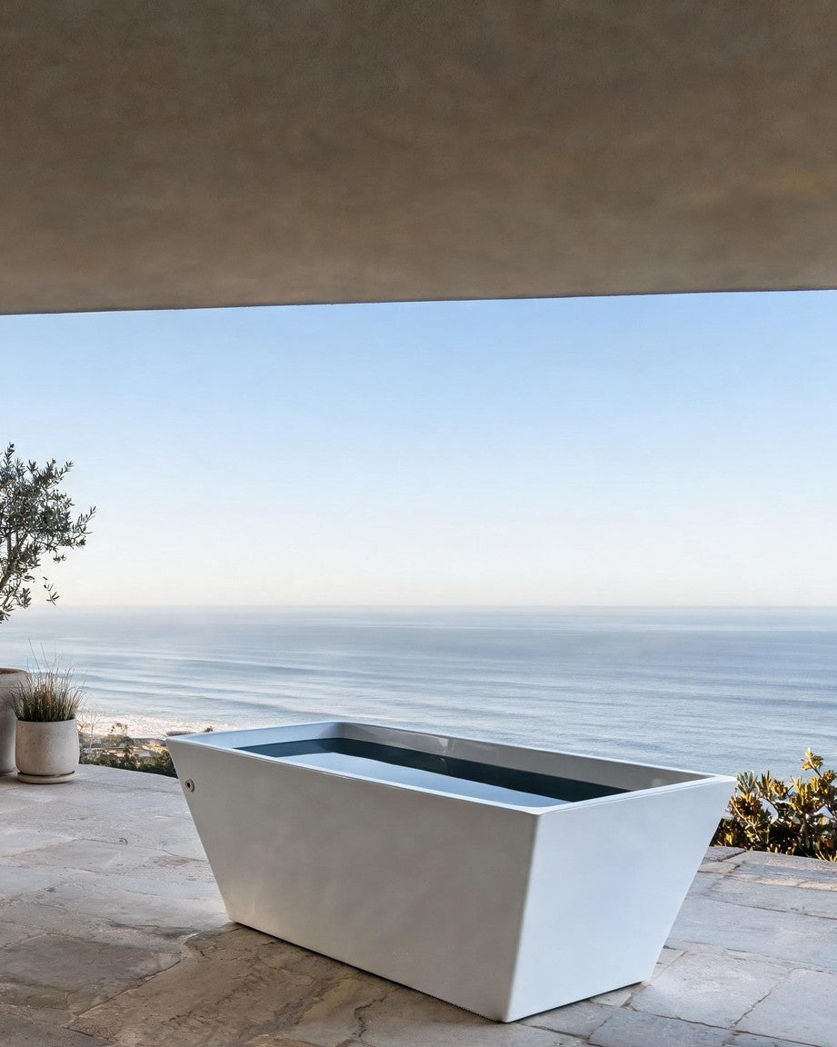 TIDE vessel in white acrylic on a stone terrace under a deep roof, the ocean behind it in morning light