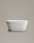 NOOK compact vessel in white acrylic, side view, on a warm grey studio background