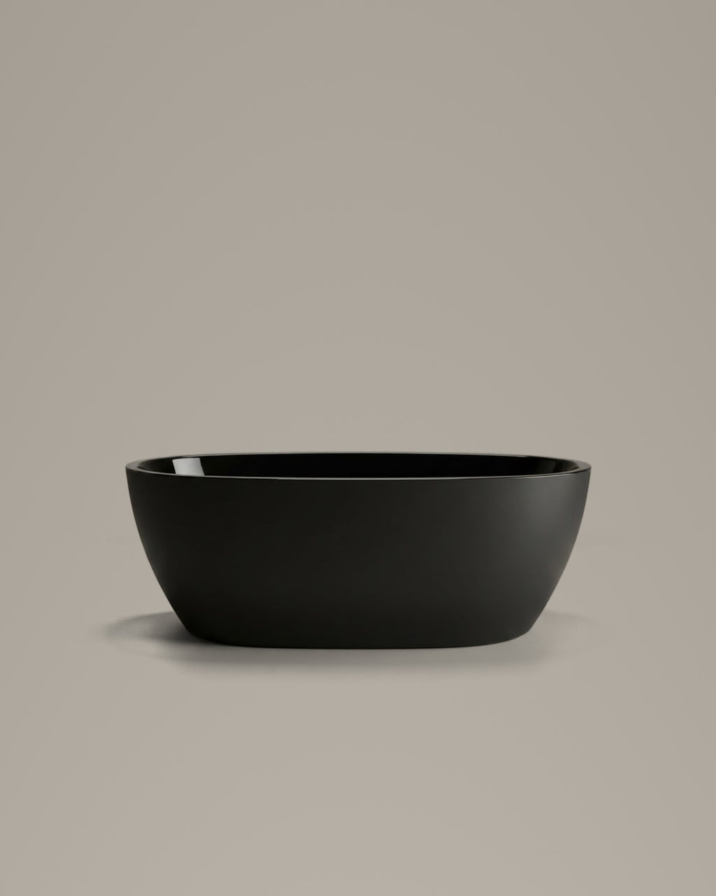 OVUM black egg-shaped vessel, side view, on a warm grey studio background