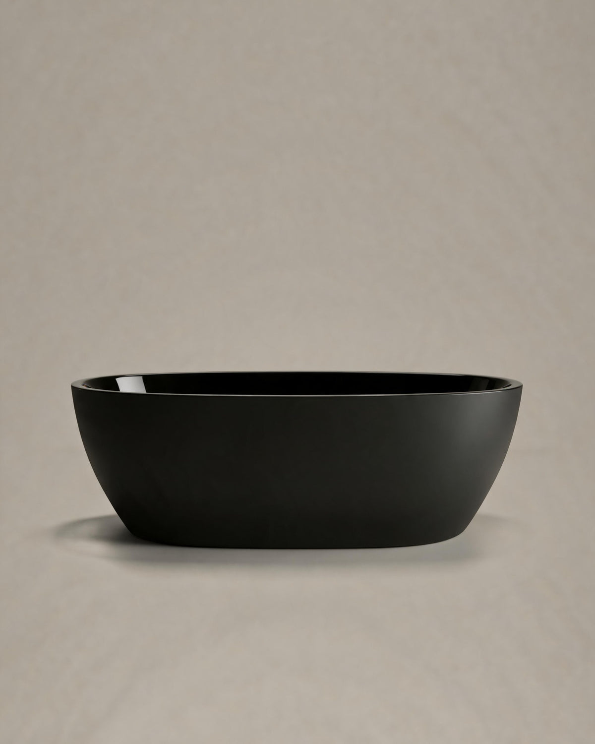 OVUM black egg-shaped vessel, side view on a warm grey studio background